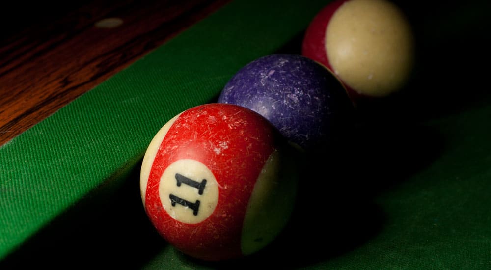 Well loved snooker balls lined up on the pool table