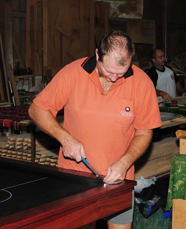 Staff member working on a pool table