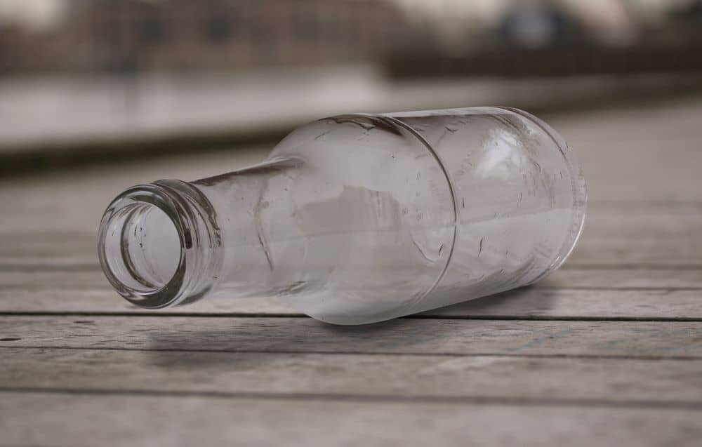 Empty bottle lying on surface of the table.