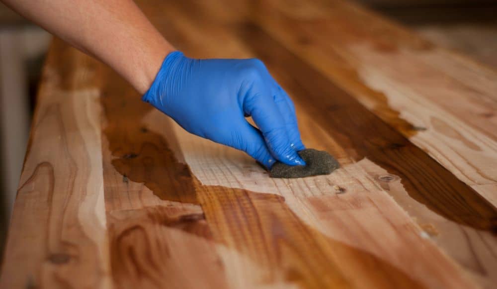 Applying oil on table surface.