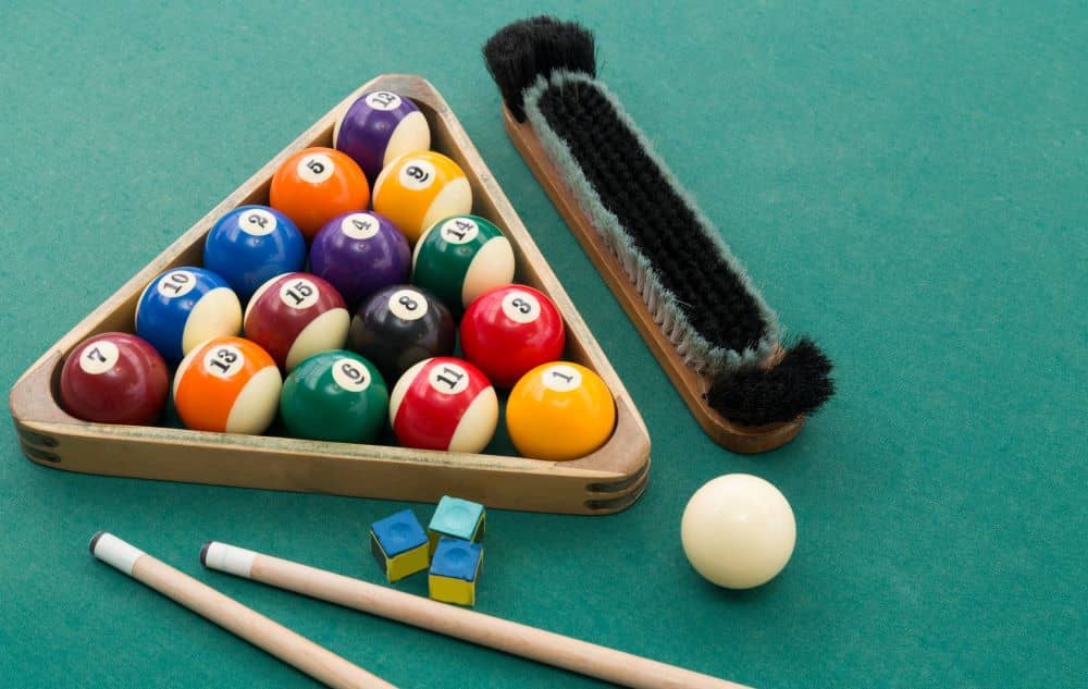 Pool cues, balls, and cleaning brush.